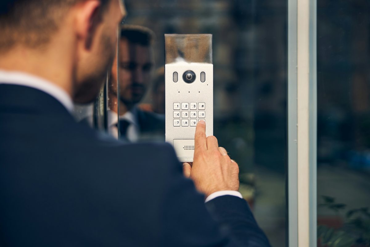 Mână introduce un cod pe un sistem de acces securizat